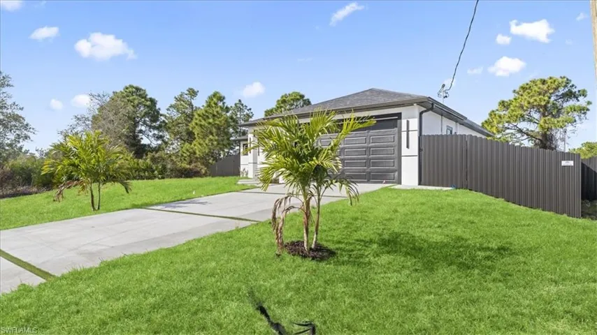 View of front facade featuring driveway, a garage, and stucco siding