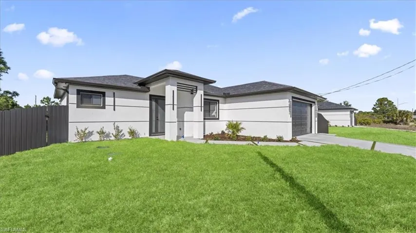 Prairie-style home featuring stucco siding, driveway, an attached garage, and roof with shingles