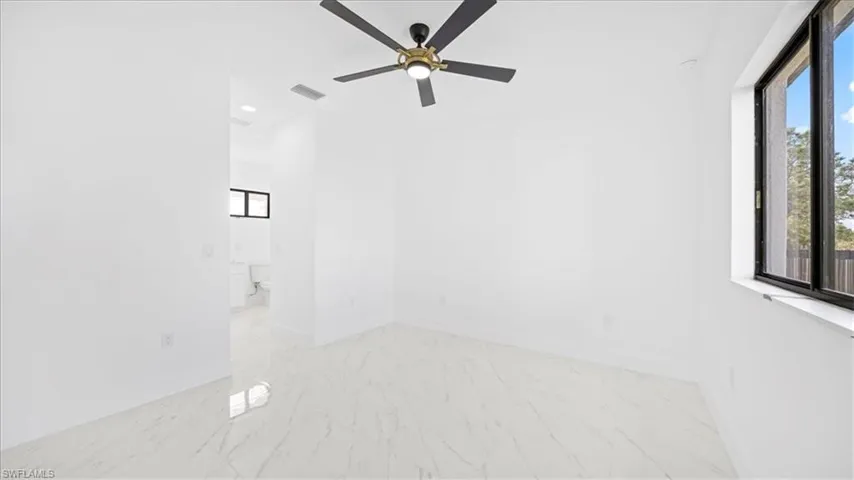 Spare room with ceiling fan and light marble finish flooring