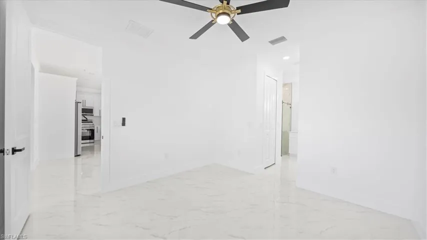 Empty room featuring light marble finish floors, recessed lighting, and ceiling fan