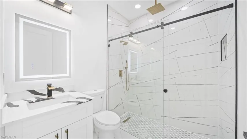 Bathroom with a marble finish shower and vanity