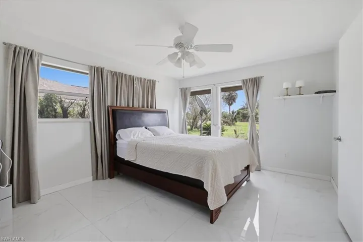 Bedroom featuring ceiling fan and light marble finish floors