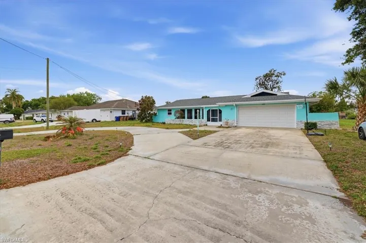 Ranch-style house featuring concrete driveway, a garage, and a front yard