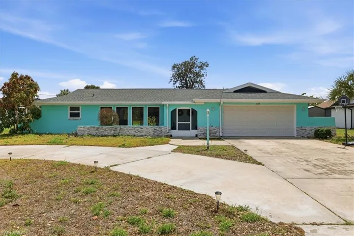 Single story home featuring concrete driveway, a garage, stucco siding, and stone siding