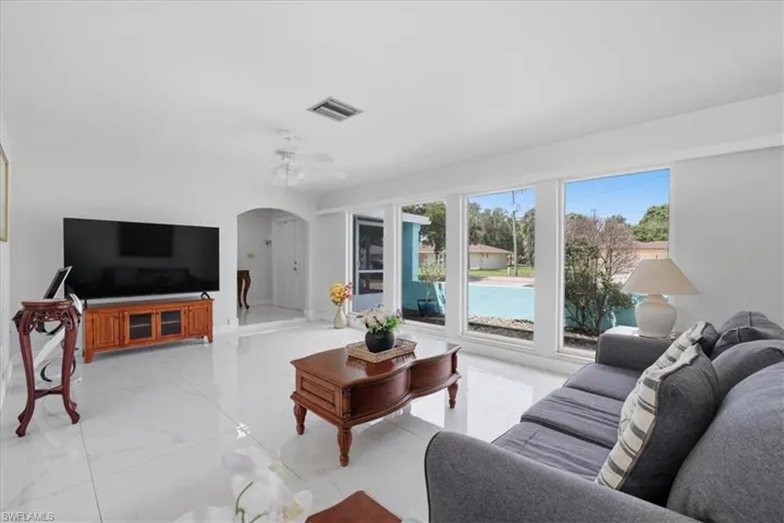 Living room with arched walkways and a ceiling fan