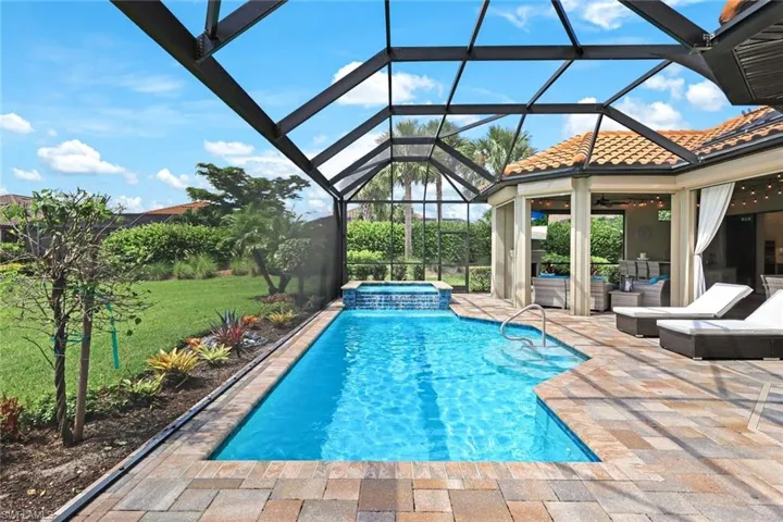 View of pool with a patio, an in ground hot tub, a lanai, a lawn, and ceiling fan