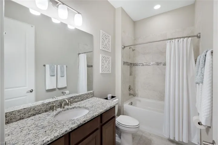 Full bathroom featuring vanity, toilet, and shower / tub combo with curtain
