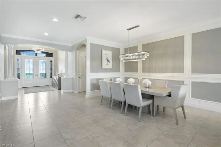 Dining area featuring crown molding, with crystal chandelier, wall deco