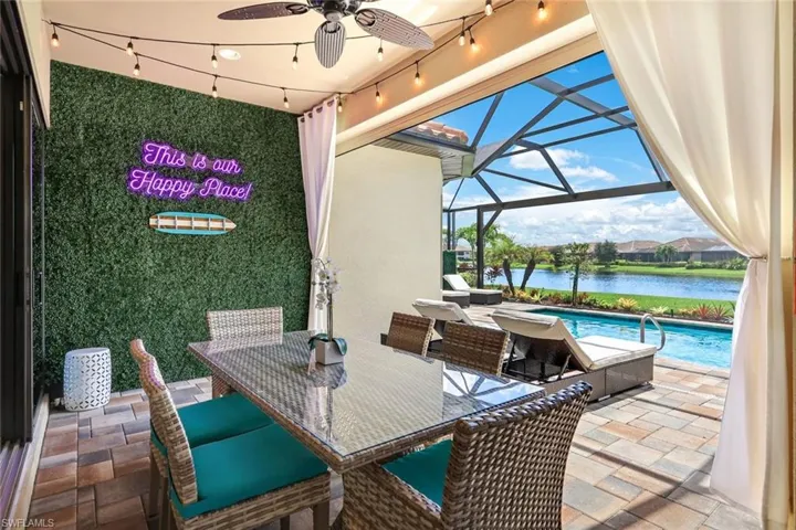 View of lanai with screen enclosure, a water view, and ceiling fan