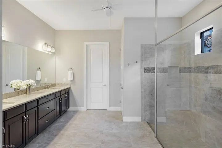 Bathroom with dual vanity, and double tiled shower
