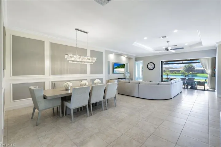 Open dining area with stunning chandelier ornamental molding, and a tray ceiling