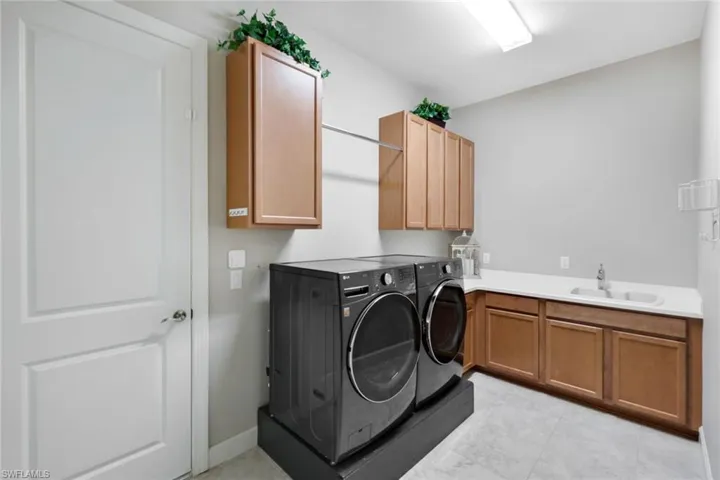 Washroom featuring cabinets, New LG washing machine and dryer, and sink
