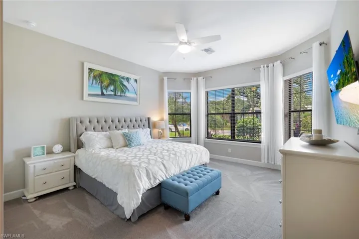 Carpeted bedroom featuring ceiling fan