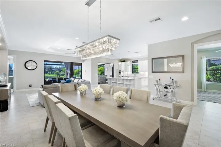 Open dining area with stunning chandelier ornamental molding, and a tray ceiling