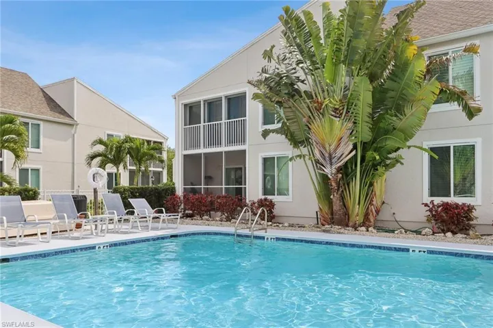 Community pool with a patio area, a balcony, and a sunroom