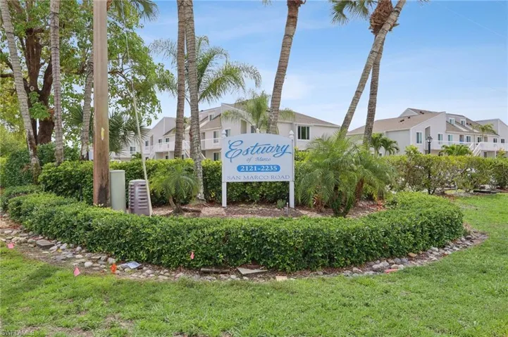 Community sign with a yard and a residential view
