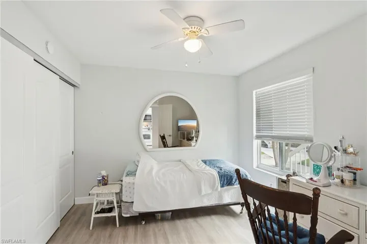 Bedroom with light wood-style flooring, a closet, and ceiling fan