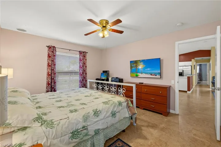 Bedroom featuring baseboards, stainless steel fridge, and ceiling fan