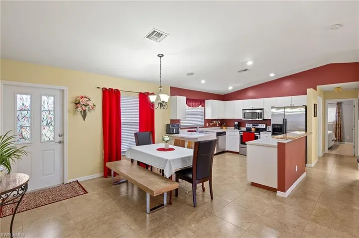 Dining room with visible vents, baseboards, lofted ceiling, and an inviting chandelier