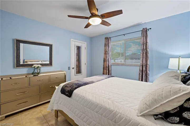 Bedroom with light tile patterned floors and a ceiling fan