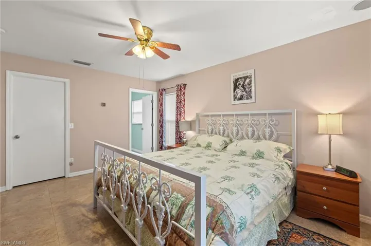 Bedroom with tile patterned flooring, visible vents, a ceiling fan, and baseboards