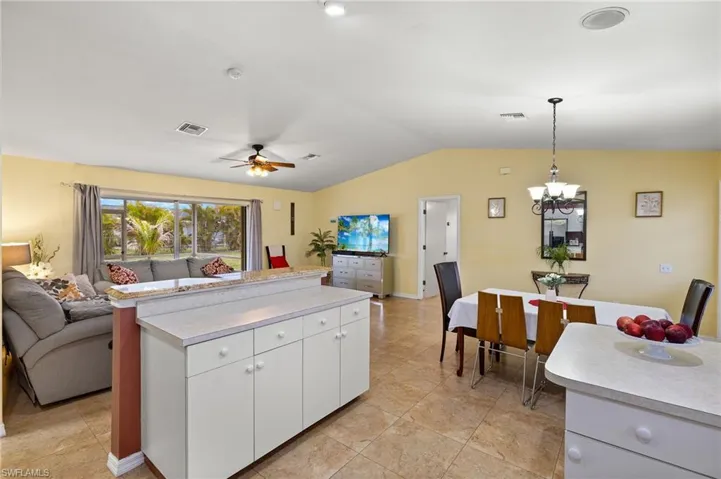 Kitchen with visible vents, open floor plan, light countertops, vaulted ceiling, and hanging light fixtures