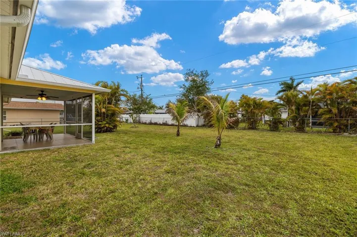View of yard featuring ceiling fan, a patio, a fenced backyard, and a sunroom