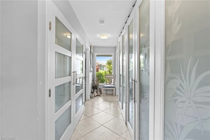 Hallway with light tile patterned floors and french doors