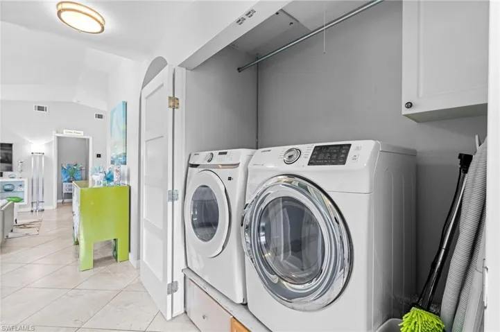 Laundry area with light tile patterned floors and washer and dryer