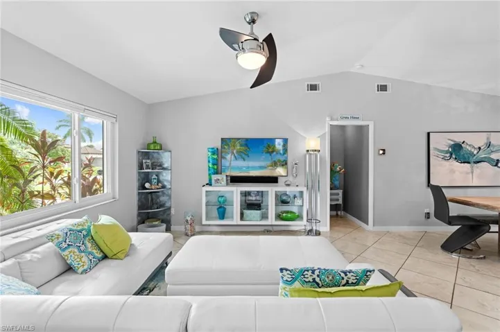 Tiled living room with vaulted ceiling and ceiling fan