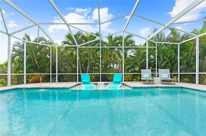 View of swimming pool featuring pool water feature and glass enclosure