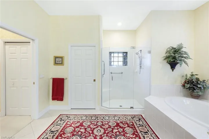 Bathroom with tile patterned floors and shower with separate bathtub