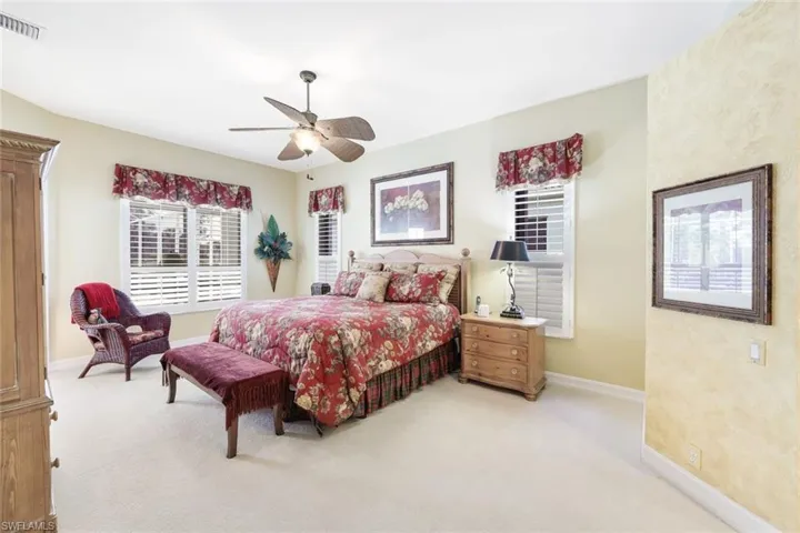 Bedroom with ceiling fan and light colored carpet