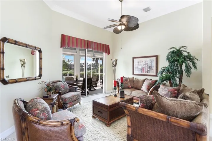 Living room featuring ceiling fan, crown molding, and light tile patterned floors