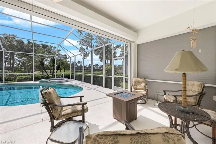 View of swimming pool with a patio, a lanai, an in ground hot tub, and an outdoor fire pit