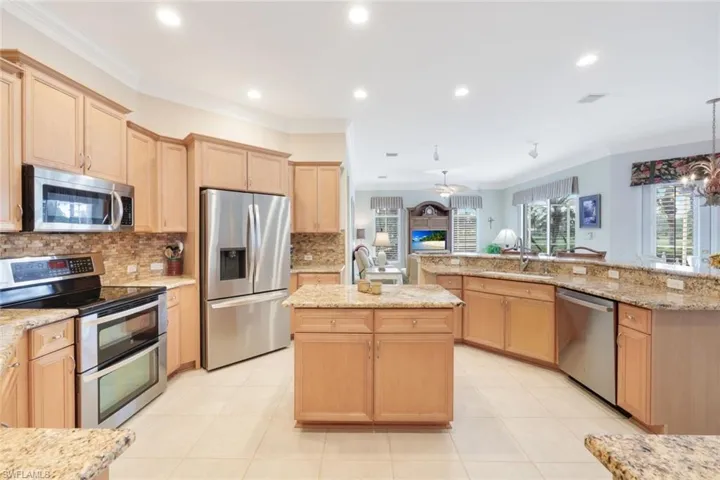 Kitchen featuring crown molding, stainless steel appliances, sink, and an island with sink