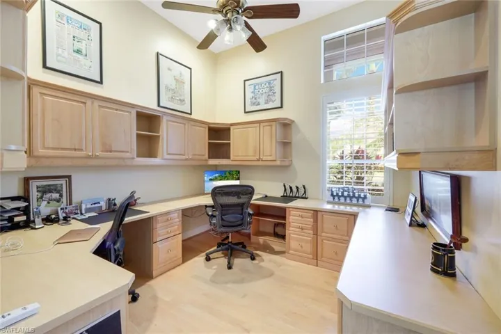 Home office featuring light hardwood / wood-style floors, built in desk, and ceiling fan