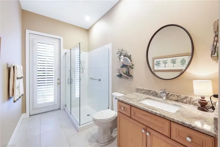 Bathroom featuring vanity, toilet, tile patterned floors, and an enclosed shower