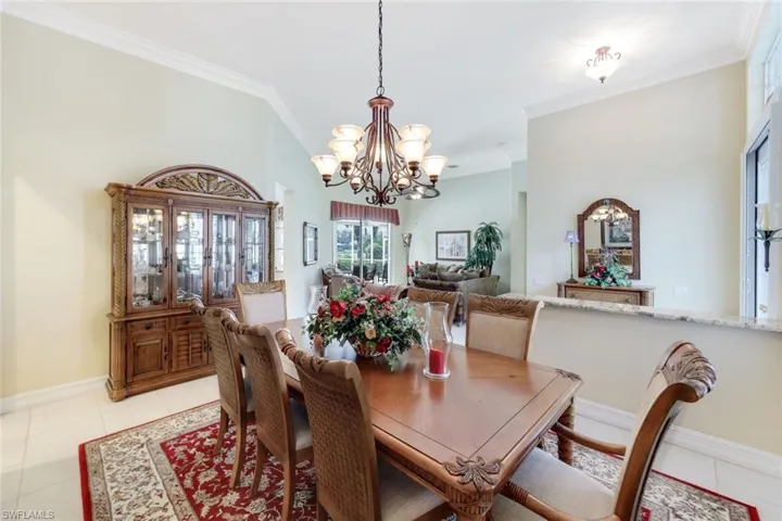 Dining room featuring crown molding, a notable chandelier, and light tile patterned floors