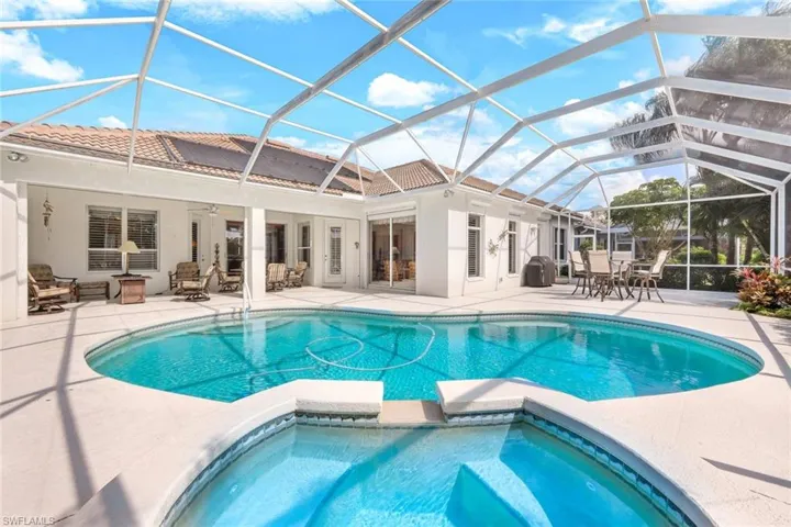 View of swimming pool featuring a patio area, ceiling fan, and glass enclosure