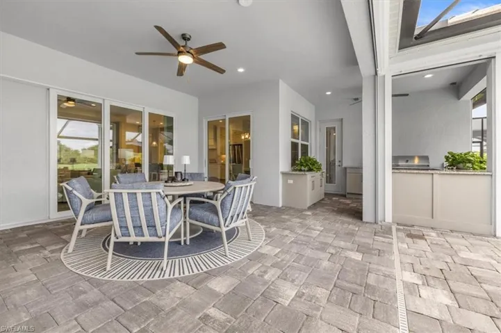 View of patio featuring outdoor dining area, an outdoor kitchen, and ceiling fan