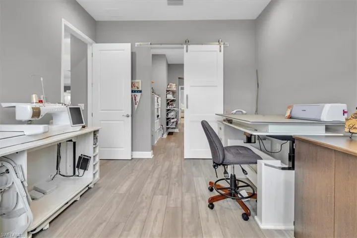 Office space with a barn door and light wood-type flooring