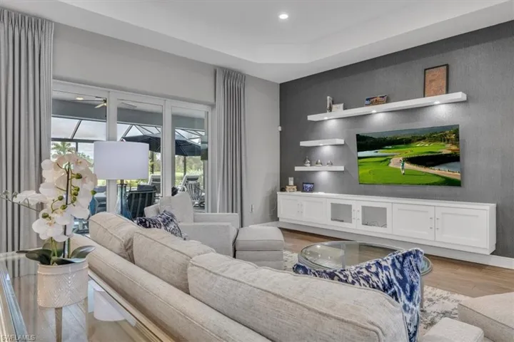 Living room with wood finished floors, a ceiling fan, and recessed lighting