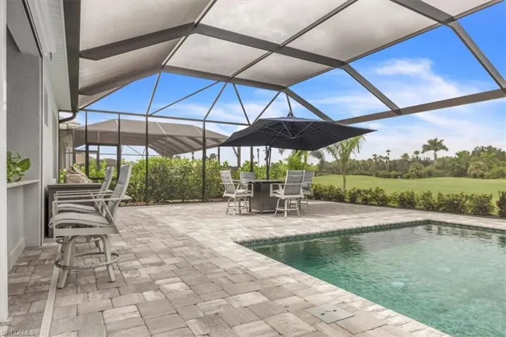 Swimming pool featuring a sunroom, a lanai, and a patio