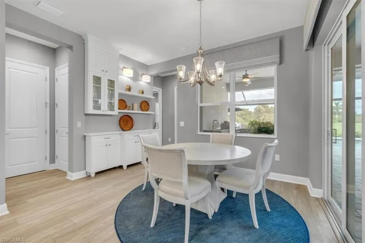Dining room with light wood-style floors, a chandelier, and ceiling fan