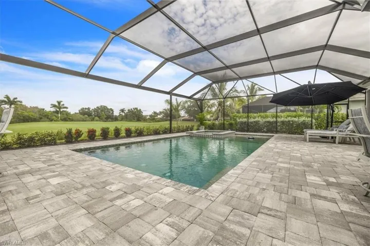 View of swimming pool with a lanai, a pool with connected hot tub, a sunroom, and a patio
