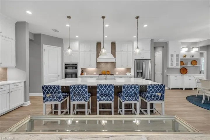 Kitchen with decorative backsplash, hanging light fixtures, appliances with stainless steel finishes, and recessed lighting