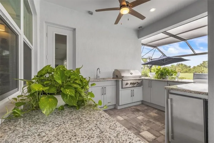 View of patio featuring a lanai, area for grilling, a ceiling fan, and a sunroom