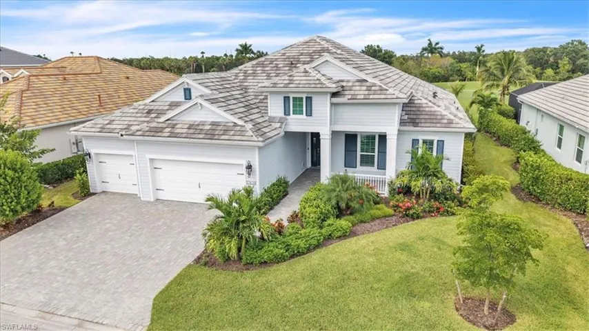 View of front of property featuring decorative driveway, a garage, a front lawn, and covered porch