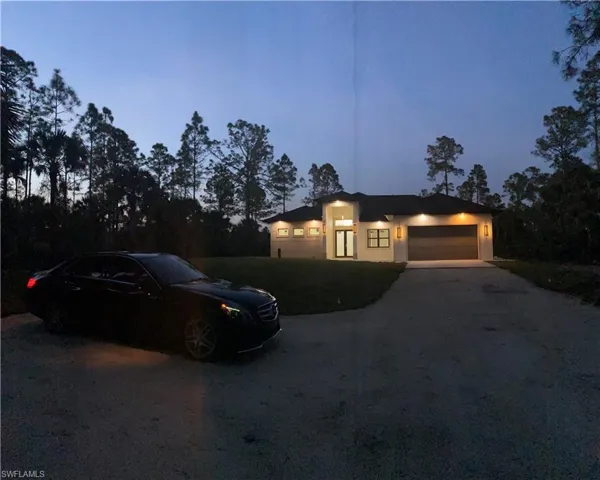 View of front of home featuring a garage, driveway, and stucco siding